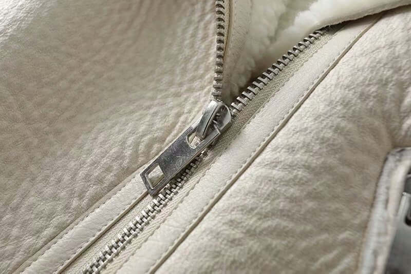 Close-up view of high-quality zipper on Annabelle Aviator Sheepskin Jacket, showcasing premium craftsmanship and elegant design.