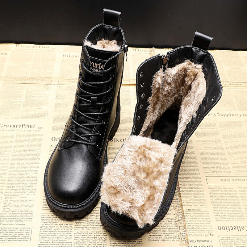 Black leather winter boots with plush fur lining on newspaper background, showcasing style and warmth for autumn and winter seasons.