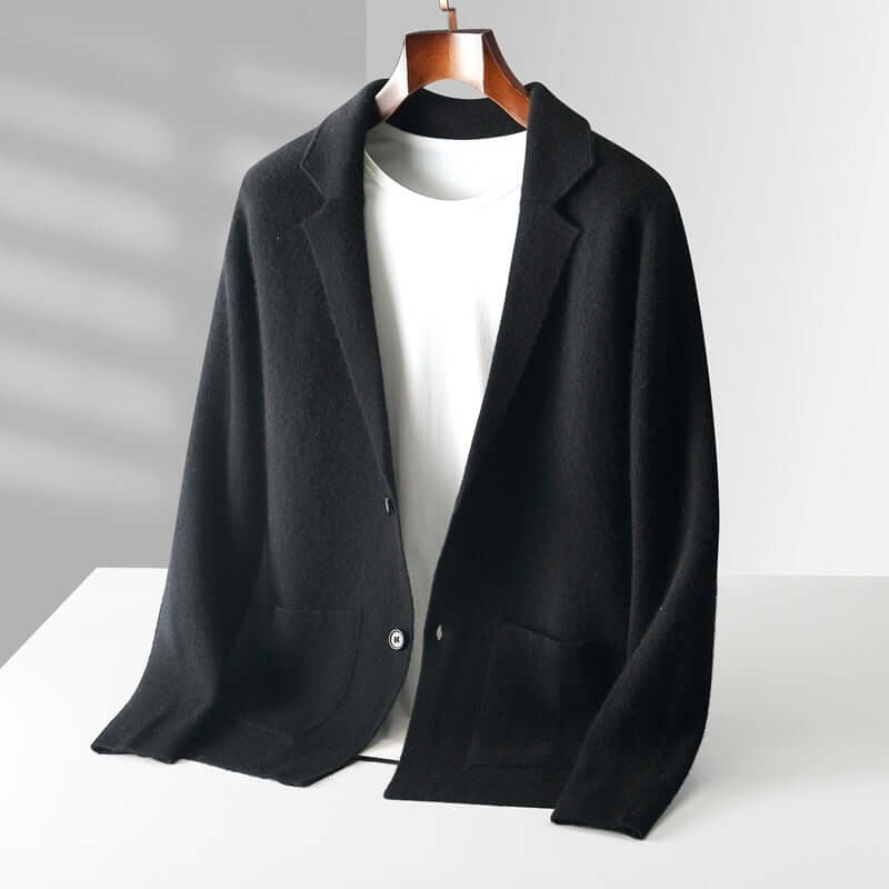 Chic black ELIJAH blazer on hanger over white top, showcasing timeless fashion and effortless elegance.