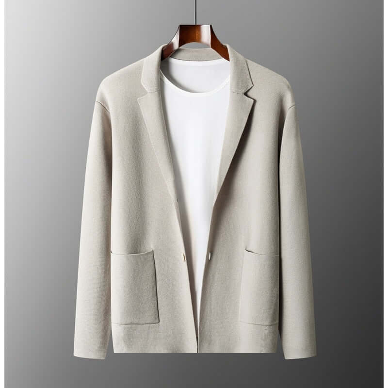 Chic beige blazer hanging on a wooden hanger, displaying a modern design with classic appeal for timeless fashion and comfort.