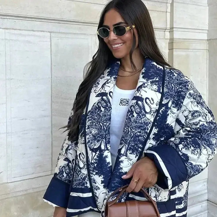 Woman wearing the Sarah Swannie Jacket, a stylish blue and white patterned fall coat, holding a brown handbag and wearing sunglasses.