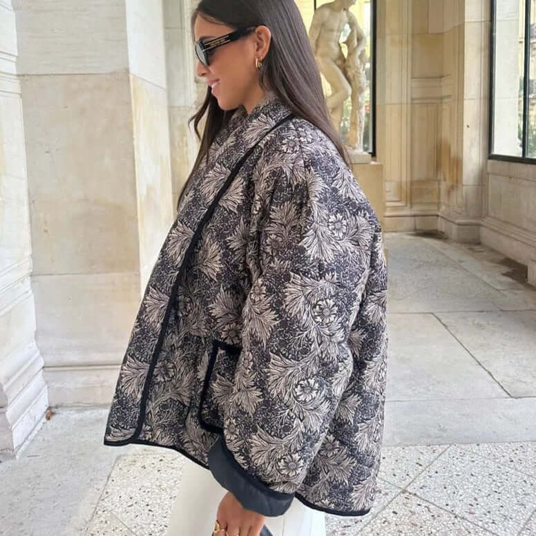 Woman wearing a stylish patterned Swannie jacket ideal for autumn, showcasing comfort and detailed design in an elegant setting.